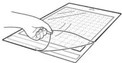 Line drawing of a hand holding a curved object over a grid-patterned sheet (no text or symbols)