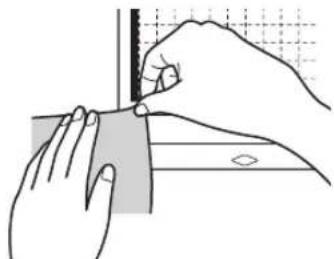 Illustration of hands using a tool to cut a rectangular object with a ruler, no text or symbols present