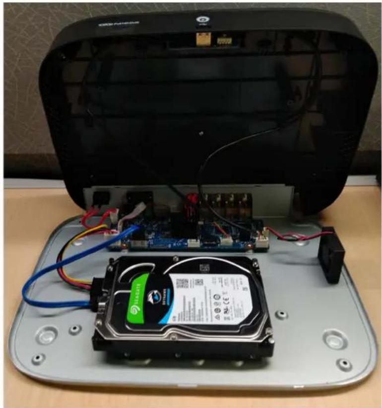 Interior view of a computer setup showing an open hard disk connected to a circuit board and a CD-ROM drive (no visible text or symbols)