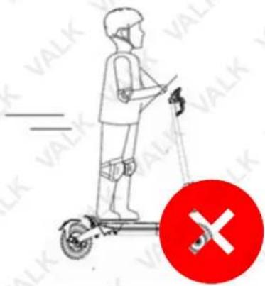 Diagram showing a person using a scooter with a red circle containing an 'X' symbol, indicating a safety or hazard warning.