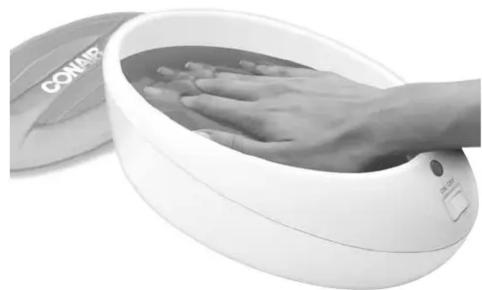Close-up of a hand washing a white circular massage device (no visible text or symbols)