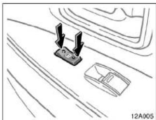 Line drawing of a mechanical component with two protruding pins, placed on a textured surface (no text or symbols)