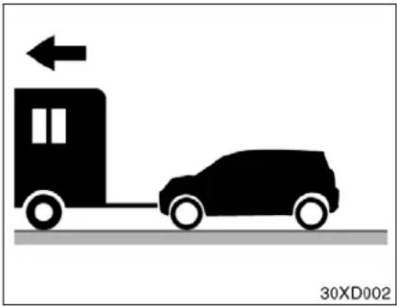 Silhouette of a car being towed by a truck, with an arrow indicating direction (no text or symbols)