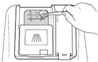 Diagram showing a hand inserting a small object into a device panel with labeled dimensions and a diagram of a chair.