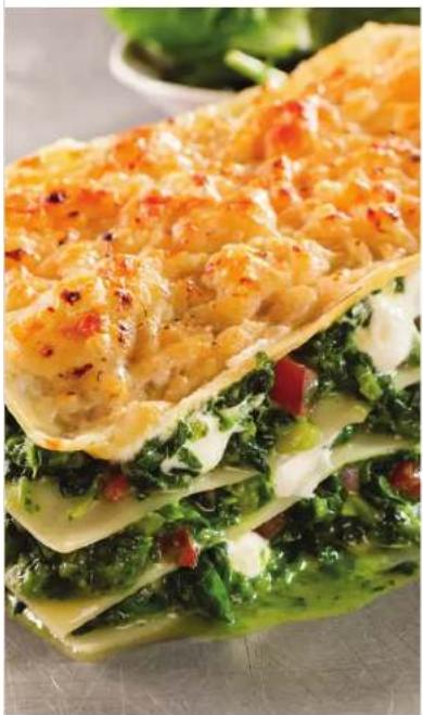 Close-up of a layered sandwich with green leafy greens and cheese, no visible text or symbols