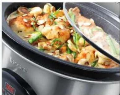 Close-up of a hot pot dish with stir-fried ingredients and green onions, served in a black ceramic pot (no visible text or symbols)