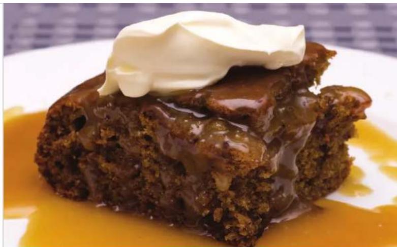 Close-up of a slice of caramel tree topping with whipped cream, served on a glossy orange sauce plate (no text or symbols visible)