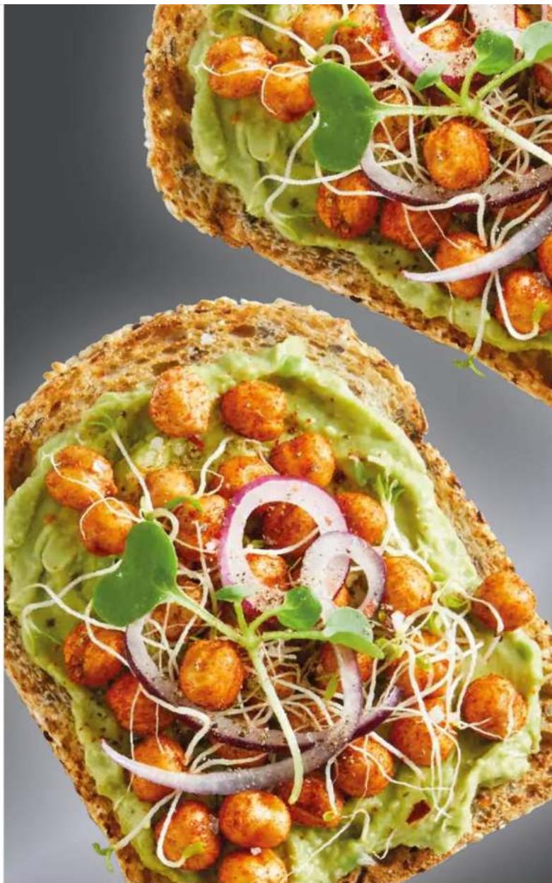 Close-up of a sandwich with fried eggplant, lettuce, and radish salad (no text or symbols visible)