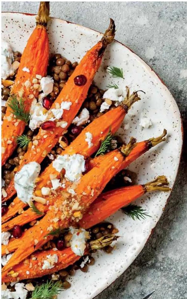 Close-up of a plated dish featuring sliced carrots with visible herbs and diced ingredients, served on a white ceramic plate (no text or symbols)