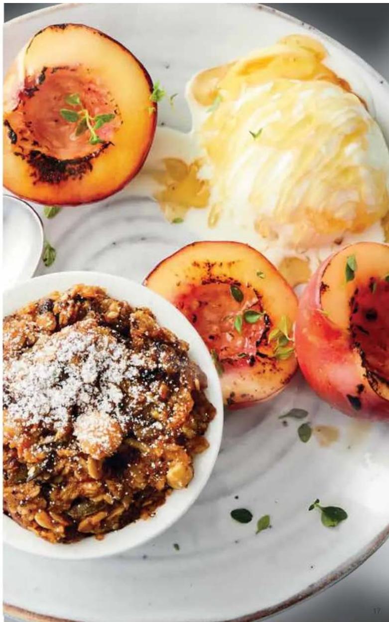 Plate of colorful food dishes including sliced cantaloupe, cream cheese, and whole fruit with garnish (no visible text or symbols)