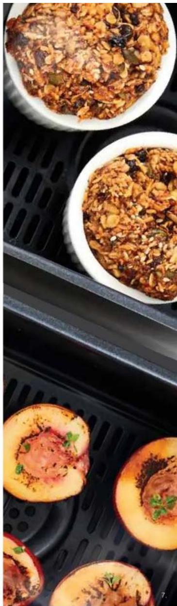 Close-up of three small bowls containing steamed bread rolls with visible toppings, placed on a black griddle tray (no text or symbols)