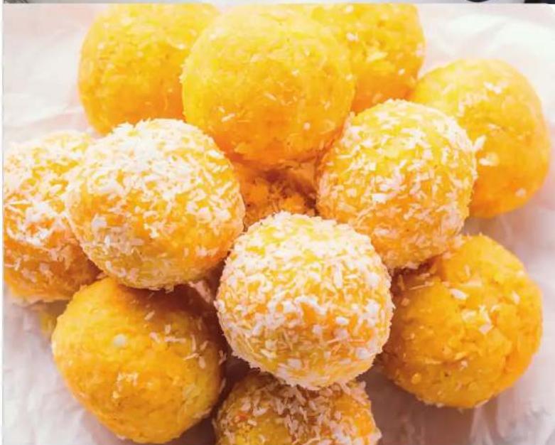 Close-up of golden-brown fried snacks with powdered sugar, arranged on a white surface (no text or symbols visible)
