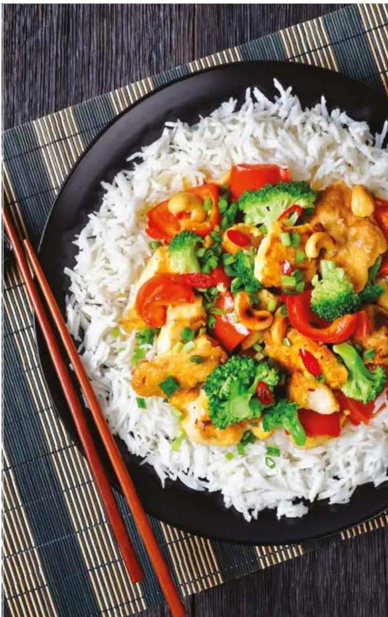 Plate of stir-fried rice with broccoli, red peppers, and sauce served on a bamboo mat (no text or symbols visible)