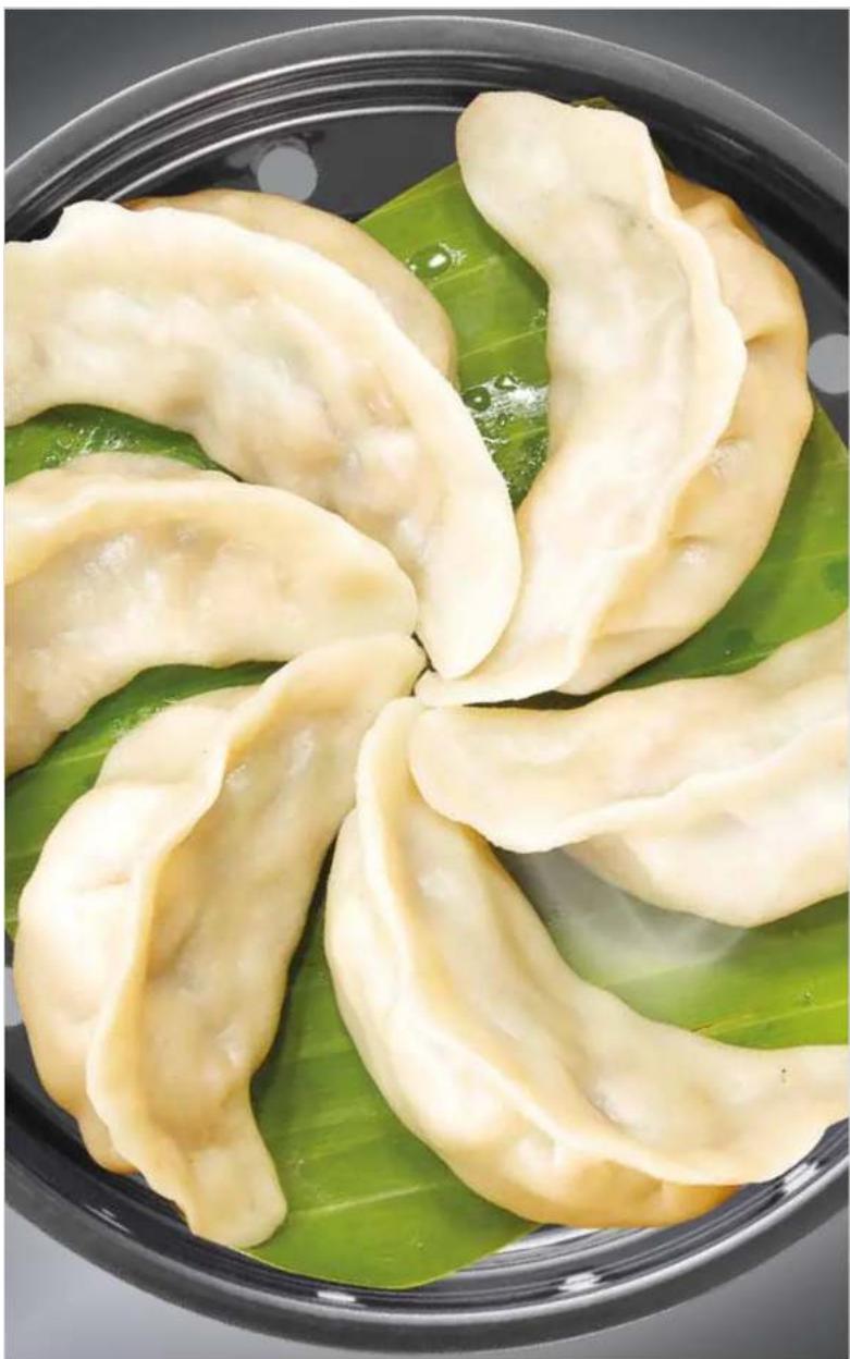 Close-up of sliced dumplings served on a green leaf plate (no text or symbols visible)