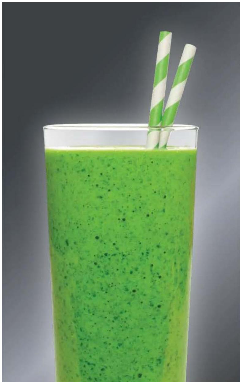 Glass of green smoothie with two straw cutters, no text or symbols visible