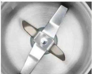 Close-up of a metallic kitchen fan blade with three blades, no text or symbols visible
