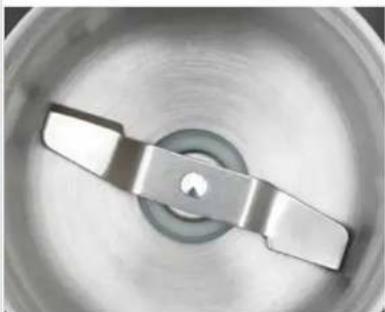 Close-up of a metallic mechanical component with a circular center and two blades (no text or symbols visible)