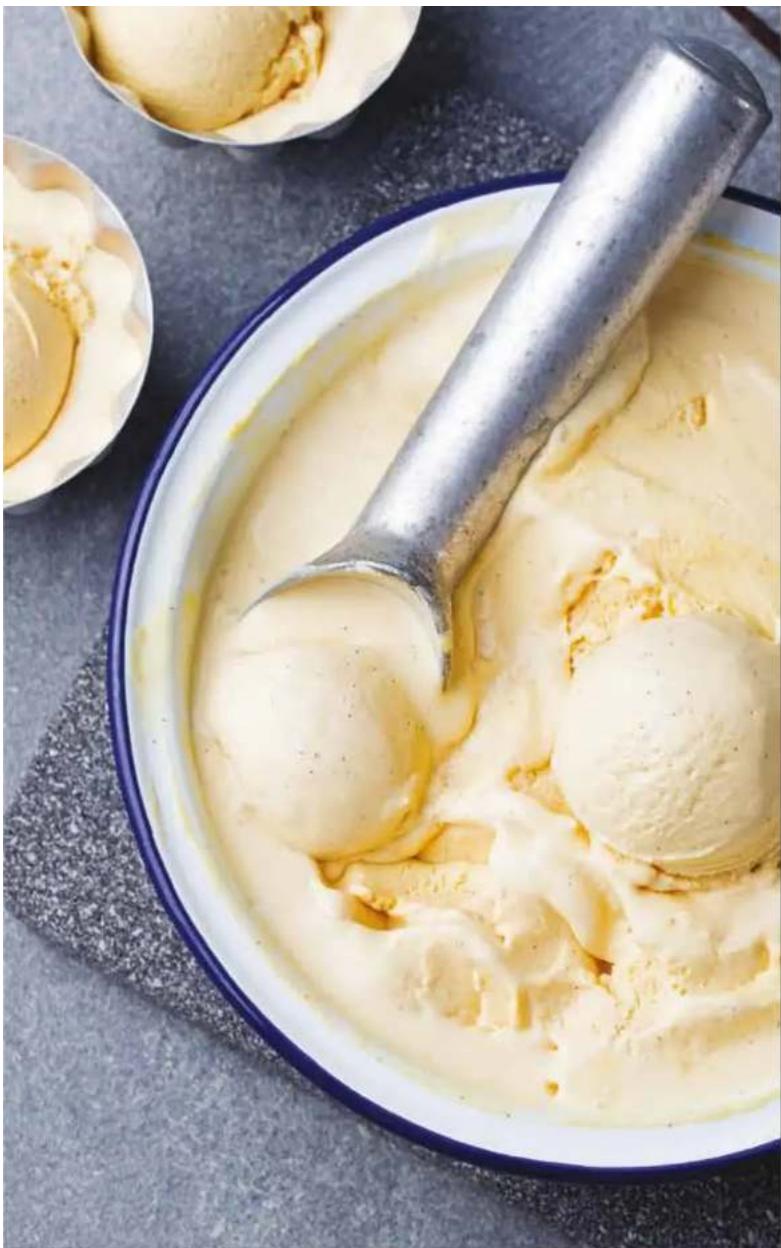 Close-up of a bowl of ice cream with two scoops, one being brushed with a metal scoop (no text or symbols visible)