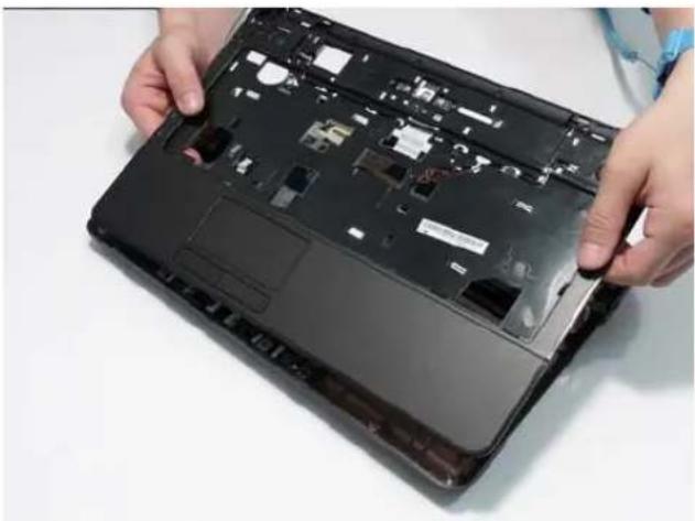 Close-up of hands installing or adjusting a black laptop cover with visible internal components (no text or symbols).