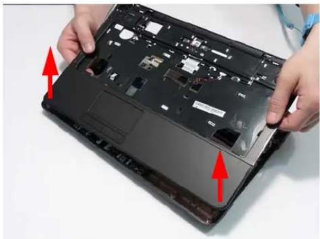 Close-up of hands installing or adjusting a laptop's front panel with visible internal components and red arrows indicating movement (no text or symbols)