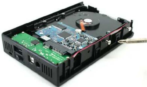 Interior view of a black hard drive with visible circuit board and internal components (no text or symbols)