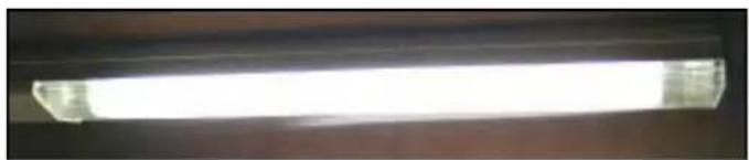 Close-up of a bright, horizontal fluorescent lamp with no visible text or symbols