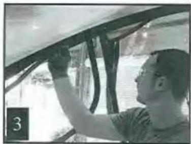 Person installing or adjusting a wall-mounted device in a vehicle (no visible text or symbols)