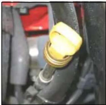 Close-up of a yellow mechanical component with threaded end, mounted on a black vehicle (no visible text or symbols)