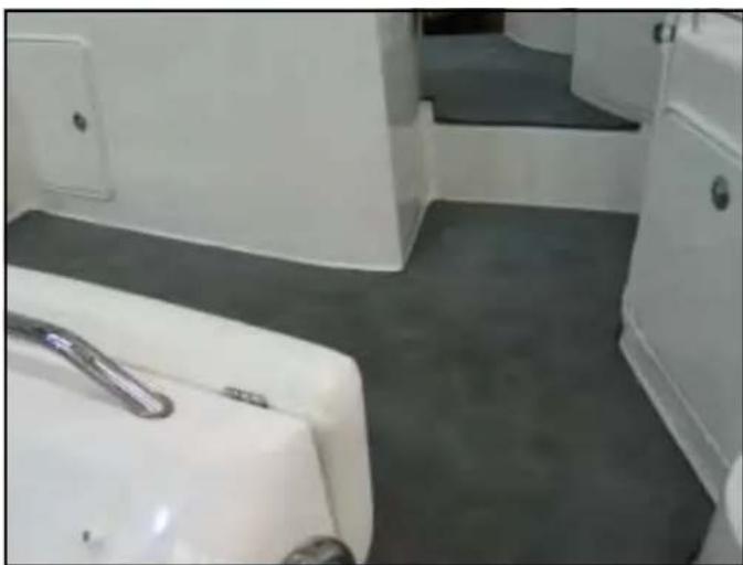 Interior view of a modern bathroom with white furniture and gray flooring (no visible text or symbols)