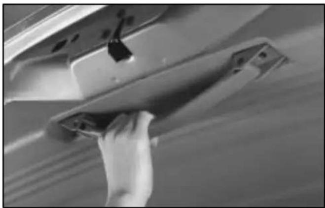 Close-up of a hand holding a metal door handle against a wooden surface (no text or symbols visible)