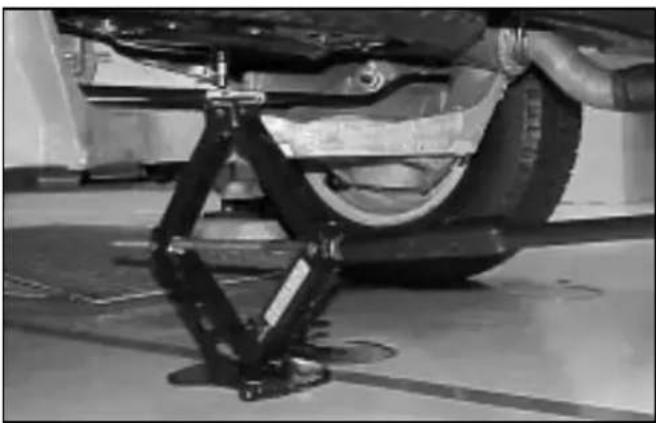 Close-up of a car suspension system mounted on a lift, showing mechanical components and wiring (no visible text or symbols)