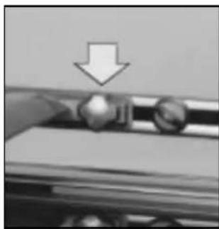 Close-up of a hand pressing down on a metal tray with a downward arrow indicating motion (no text or symbols)