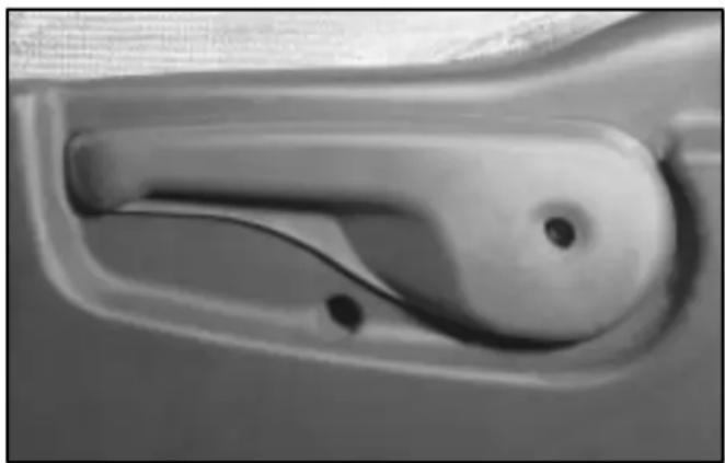 Close-up of a car handle with a cable and circular opening (no text or symbols visible)