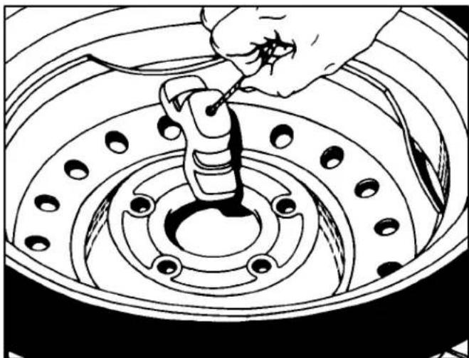 Line drawing of a hand using a tool to adjust or install a car wheel rim (no text or symbols present)