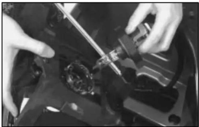 Close-up of hands installing or adjusting a mechanical component on a dark surface (no visible text or symbols)