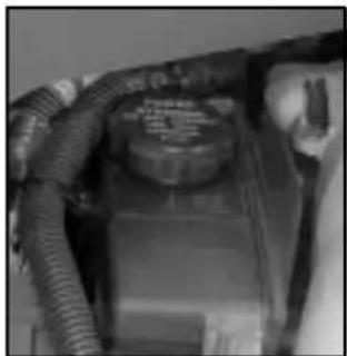 Close-up of a mechanical component with coiled tubing and a central circular component (no visible text or symbols)
