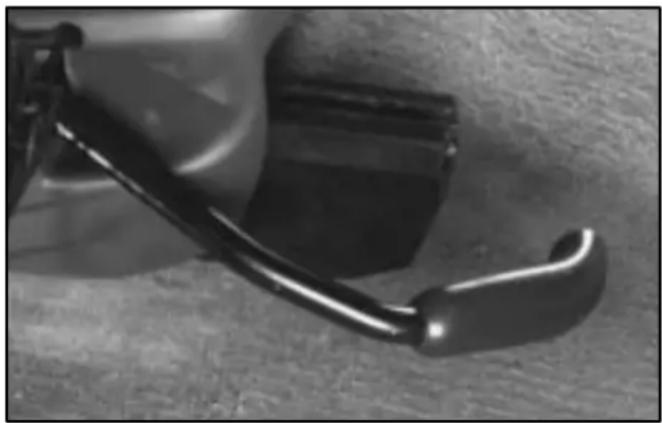 Close-up of a black mechanical component with a curved handle and textured surface (no visible text or symbols)