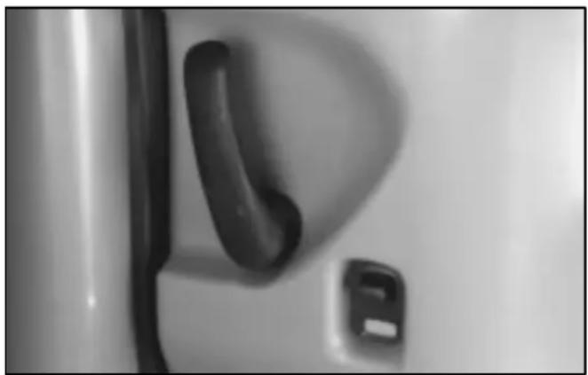 Close-up of a door handle and side panel, no visible text or symbols