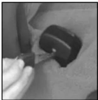 Close-up of a hand using a tool to adjust or install a dark mechanical component (no visible text or symbols)