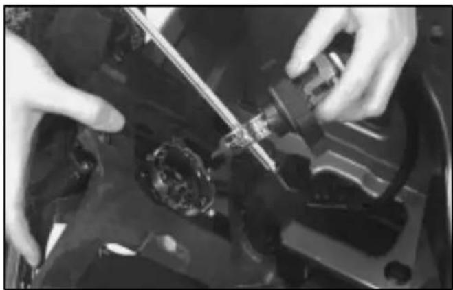 Close-up of hands installing or adjusting a mechanical component on a vehicle head (no visible text or symbols)