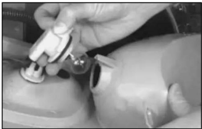 Close-up of a hand adjusting a small mechanical component, possibly a valve or sensor device (no visible text or symbols)