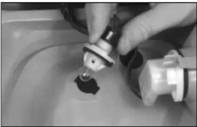 Close-up of hands using a tool to apply liquid into a container (no visible text or symbols)