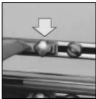 Close-up of a mechanical component with a downward arrow indicating compression or disassembly (no text or symbols visible)