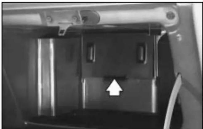 Close-up of a mechanical component with a white arrow pointing to a specific part (no text or symbols visible)