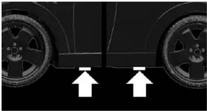 Close-up of a car wheel rim and rear wheel with white arrows pointing to the side (no text or symbols)