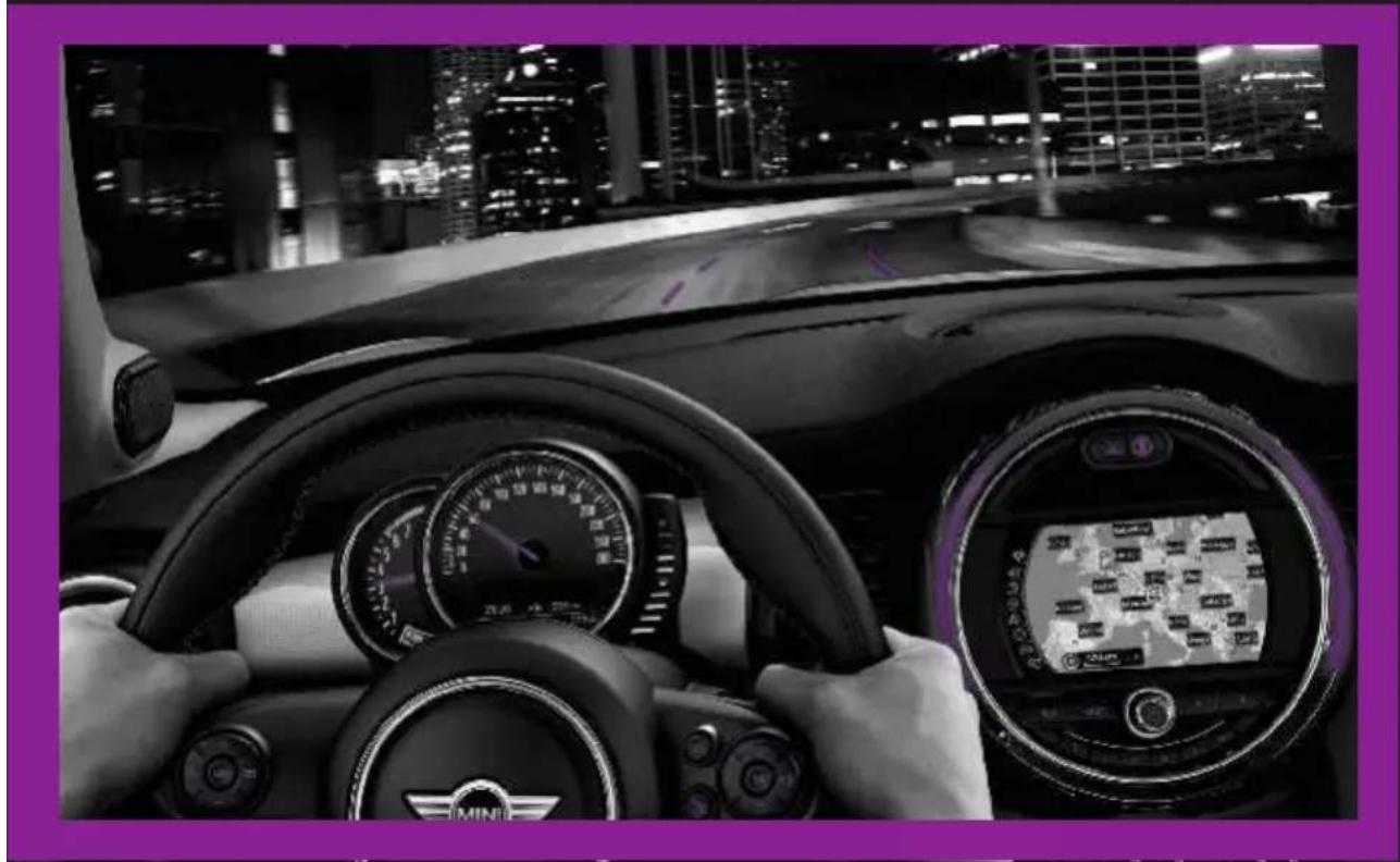 Interior view of a car with hands holding the steering wheel, dashboard, and digital navigation screen showing map or data (no readable text or symbols)