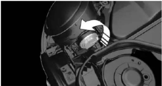 Close-up of a mechanical assembly with a white arrow pointing to a component (no visible text or symbols)