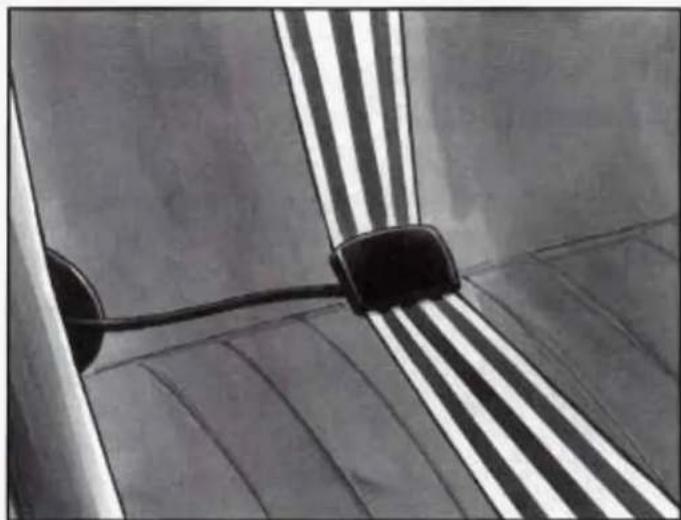 Close-up of a metallic object with striped pattern and black connectors, no visible text or symbols