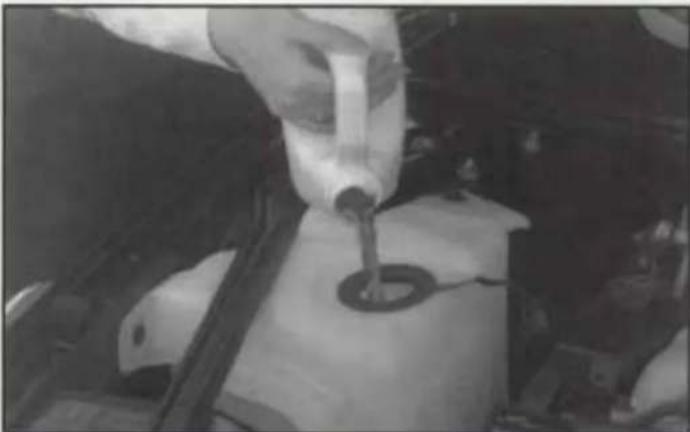 Close-up of a person using a tool to adjust or install a mechanical component, no visible text or symbols