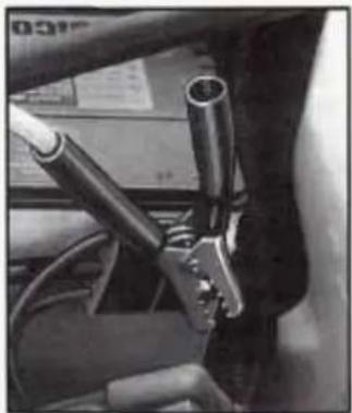 Close-up of a car's front wheel assembly with visible pipes and wiring (no text or symbols)